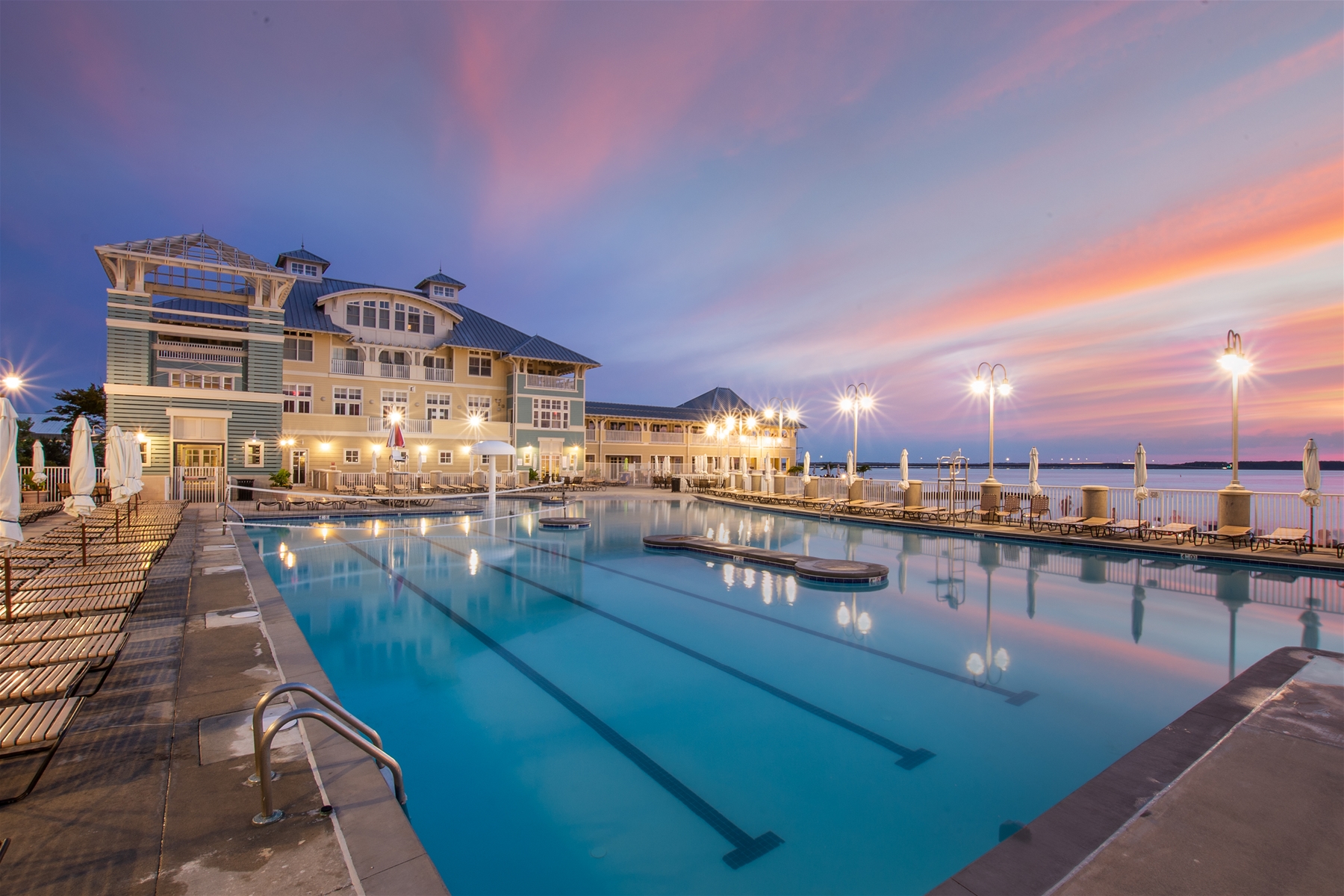 An oceanfront resort with a lap pool at sunset in Sunset Island MD